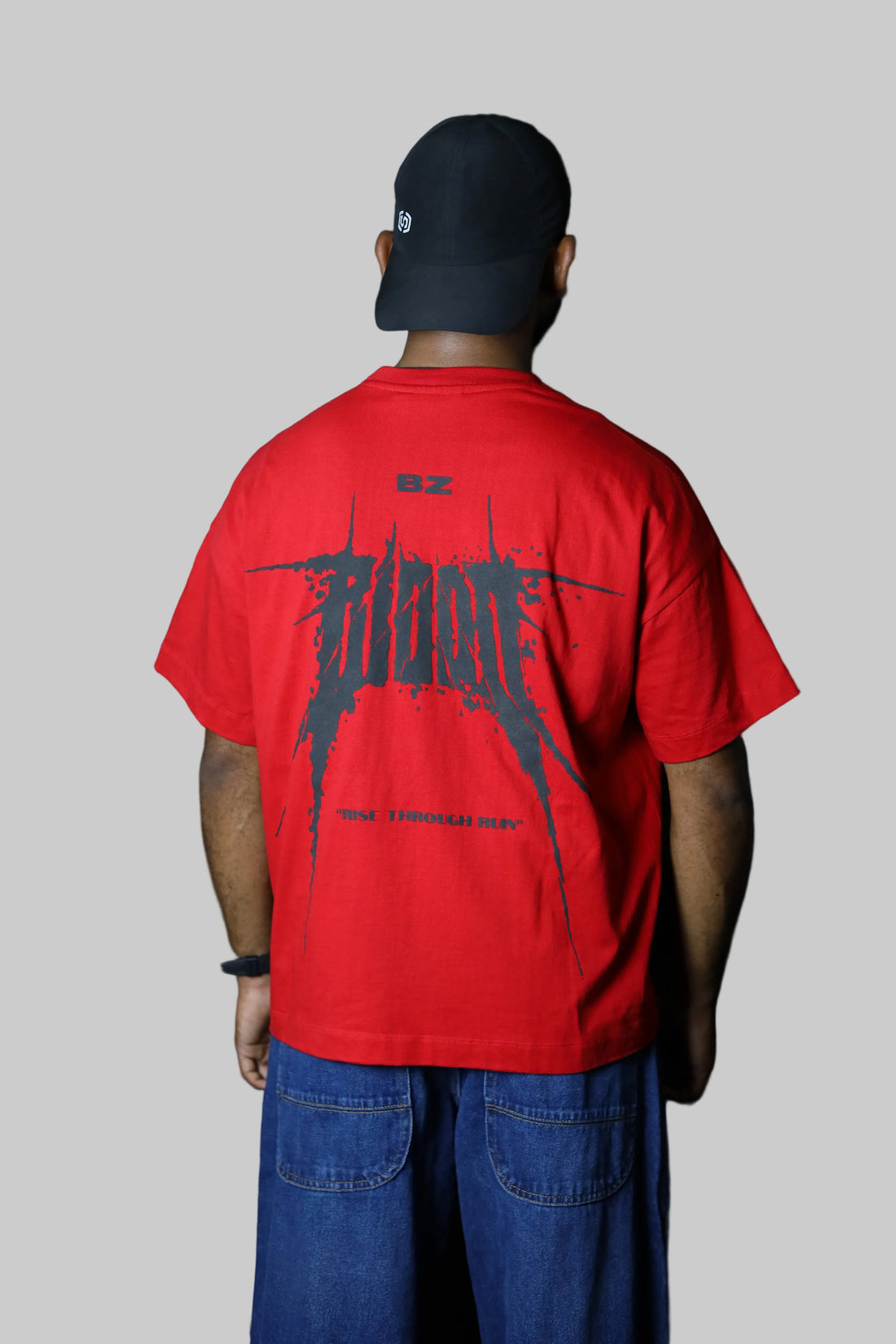 Person wearing a red shirt with 'Bally' branding on a black background